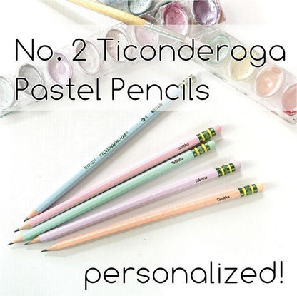 A collection of pastel-colored Ticonderoga pencils with personalized engravings, displayed alongside a transparent case filled with additional pencils in the background.