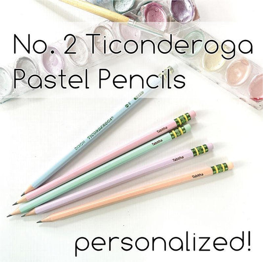 A collection of pastel-colored Ticonderoga pencils with personalized engravings, displayed alongside a transparent case filled with additional pencils in the background.